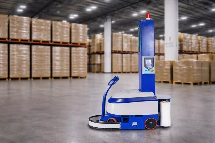 Produ��o com rob� envolvedor de pallet, em armaz�m log�stico com diversas cargas empilhadas