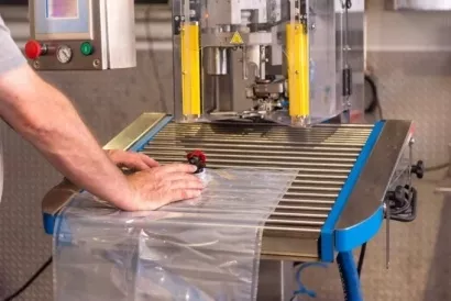 Seladora industrial em opera��o para fechamento de embalagens pl�sticas com filme.