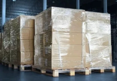 Caixas empilhadas em pallets e embrulhadas em filme strech depois de passar por envolvedoras de pallet